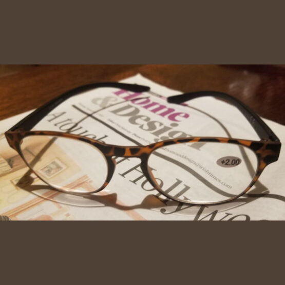 Brown reading glasses left on Irish Times